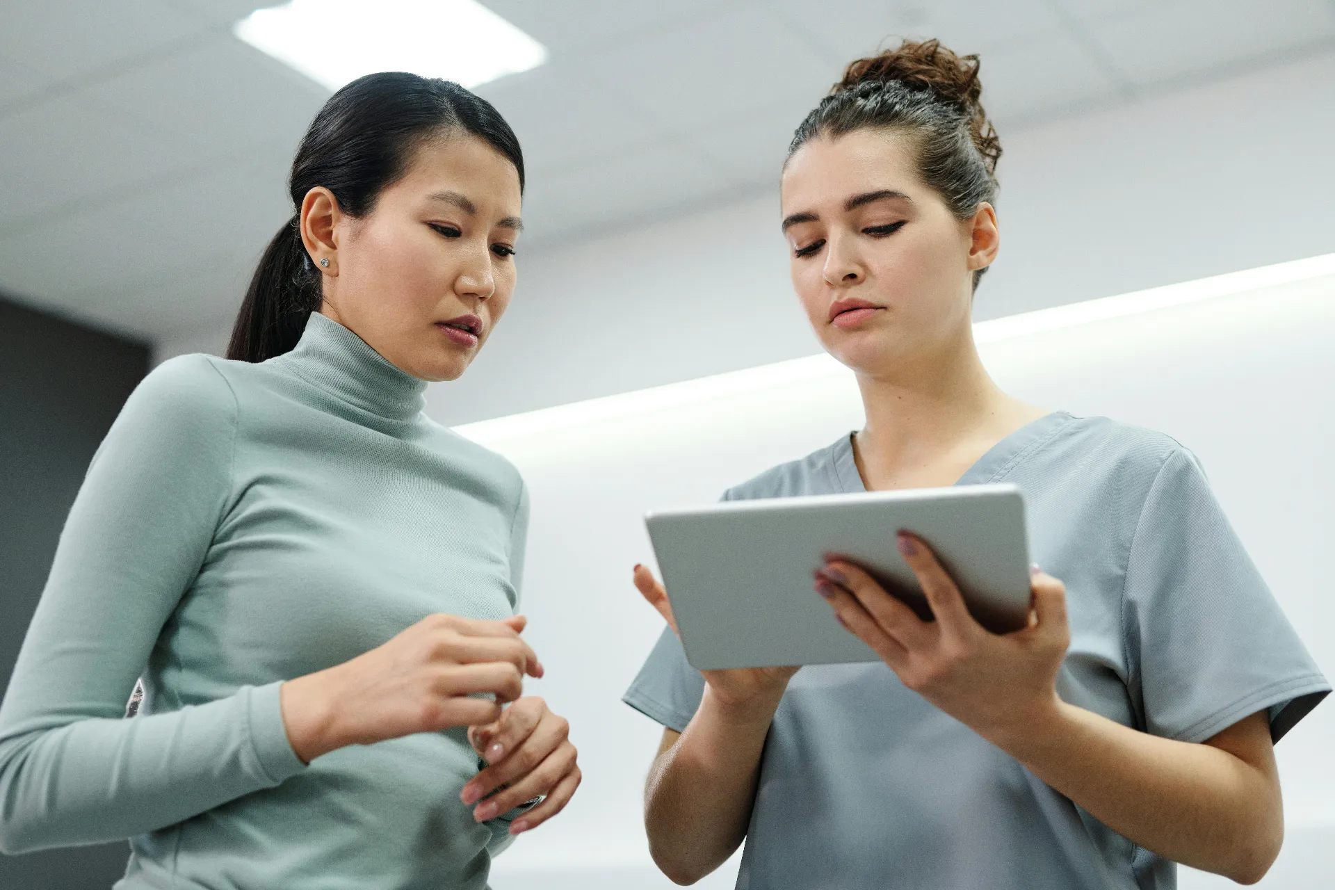 Provider and patient reviewing hormone replacement therapy cream options at a wellness consultation